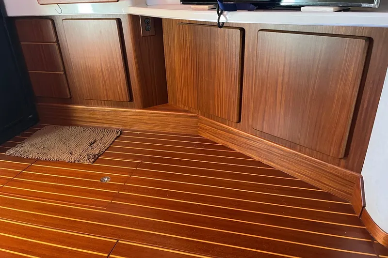 Slide: The Image of Interior of 1994 Sea Ray 400 Express Cruiser with wooden cabinets and flooring. - 15