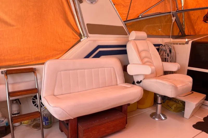 Slide: The Image of Interior of a 1994 Sea Ray 400 Express Cruiser with white seating and orange canopy. - 5