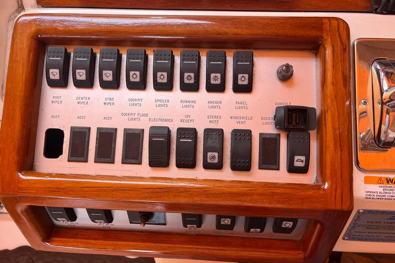 Slide: The Image of Control panel of a 1994 Sea Ray 400 Express Cruiser with labeled switches and wooden trim. - 9