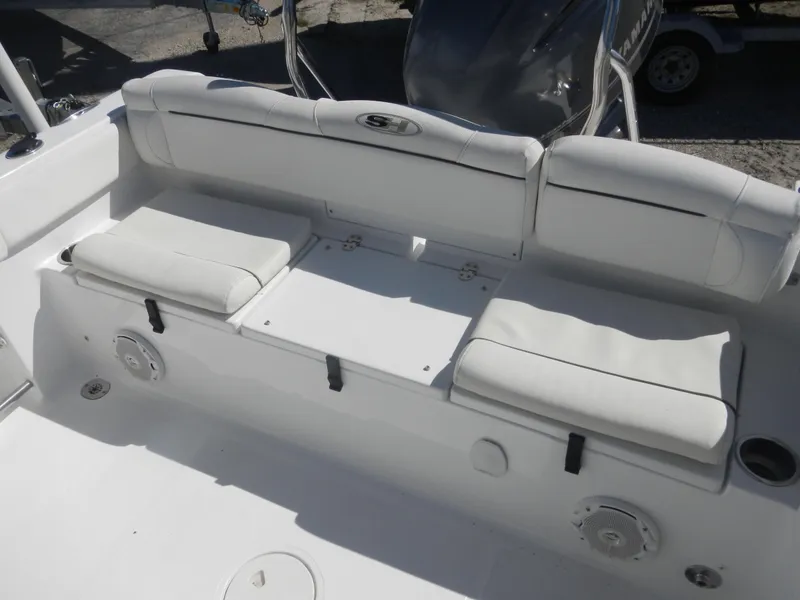 Slide: The Image of 2016 Sea Hunt Ultra 234 boat seating area with white cushioned seats and storage compartments. - 16