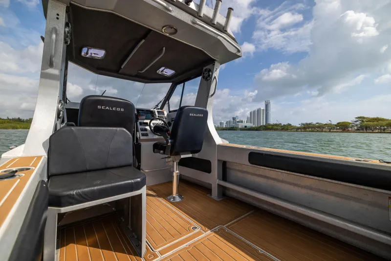 Slide: The Image of Interior of a 2022 Sealegs 8.5M boat with modern seating and scenic waterfront view. - 12