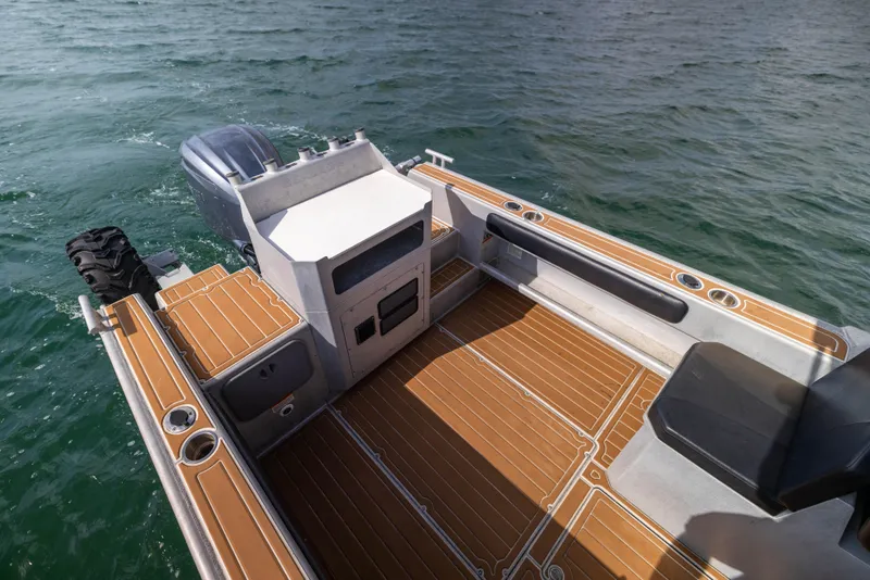 Slide: The Image of Sealegs 8.5M 2022 boat interior with wooden deck and seating on water. - 17