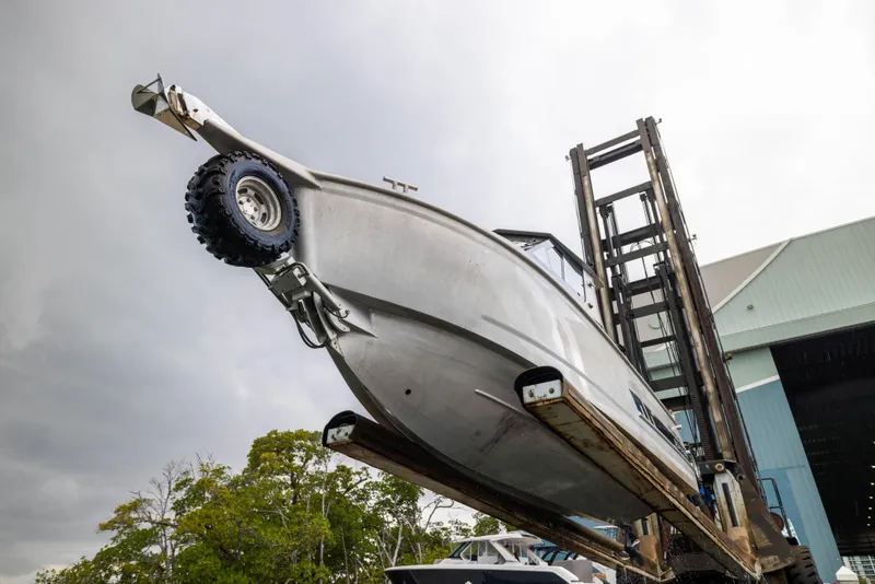 Slide: The Image of 2022 Sealegs 8.5M boat lifted by forklift near a warehouse. - 26