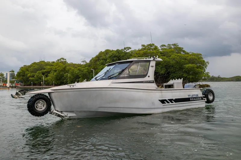 Slide: The Image of Amphibious Sealegs 8.5M boat, 2022 model, on water with wheels extended, cloudy sky background. - 28