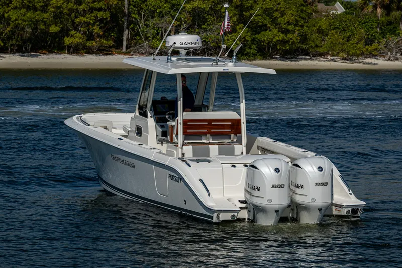 Slide: The Image of 2021 Pursuit S 288 Sport boat cruising on water with twin engines. - 14