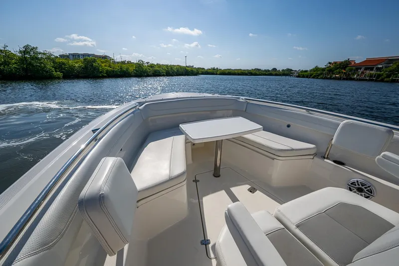 Slide: The Image of 2021 Pursuit S 288 Sport boat interior with seating and table on a sunny day. - 20