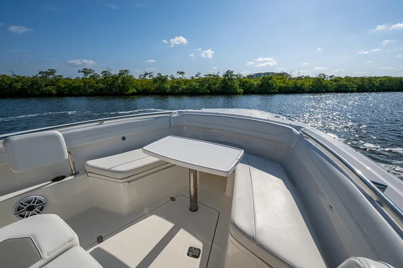 Slide: The Image of 2021 Pursuit S 288 Sport boat interior with seating and table on a sunny day. - 21