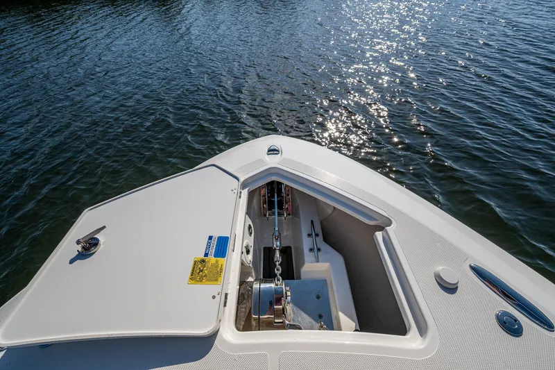 Slide: The Image of 2021 Pursuit S 288 Sport boat anchor compartment on calm water. - 22