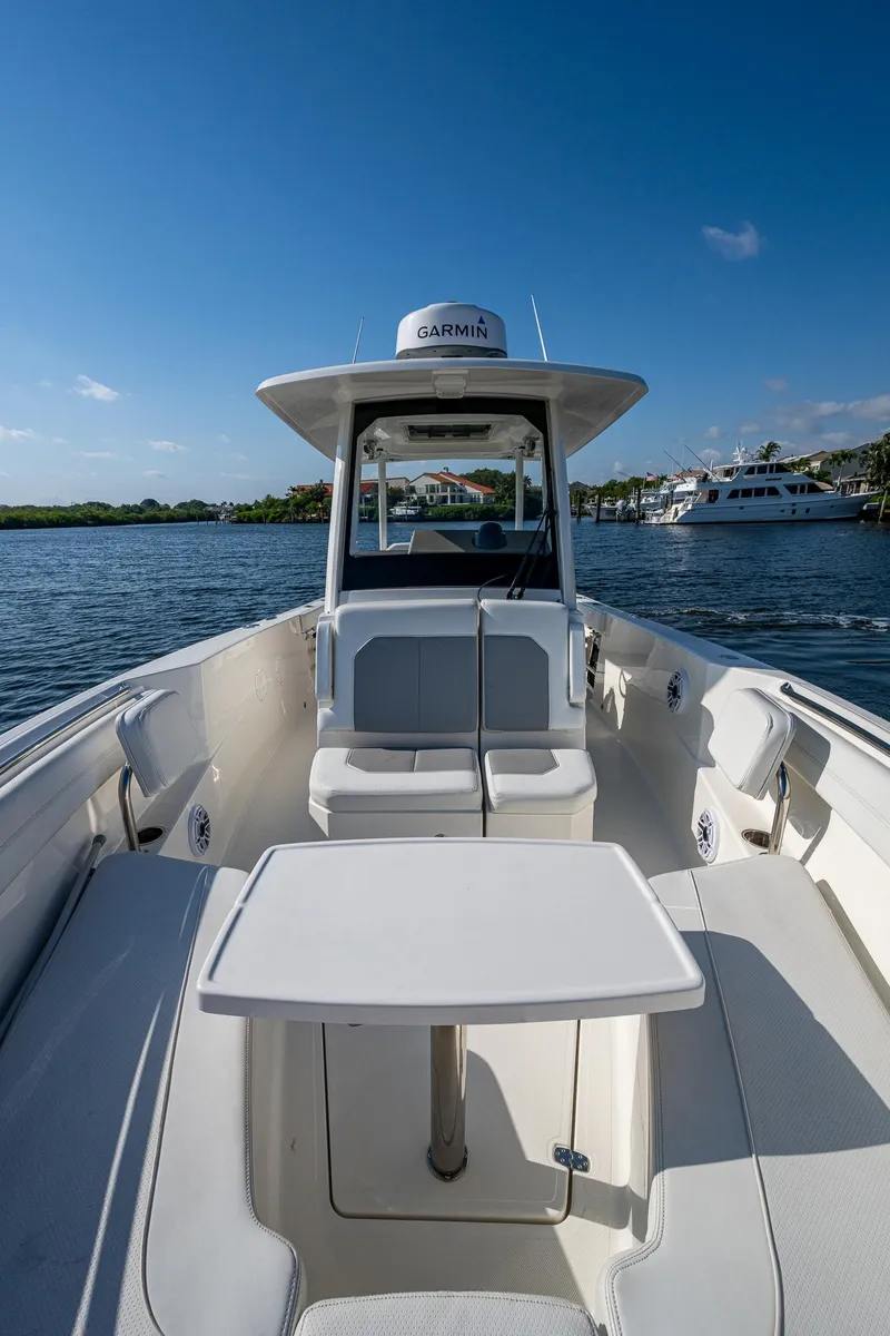 Slide: The Image of 2021 Pursuit S 288 Sport boat on water, clear sky, spacious deck, modern design. - 24