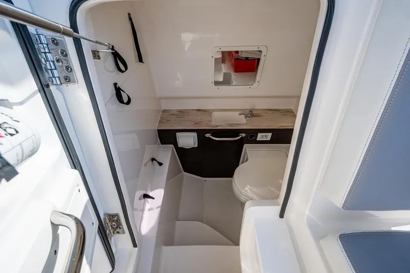 Slide: The Image of 2021 Pursuit S 288 Sport boat interior with compact bathroom and sink. - 28