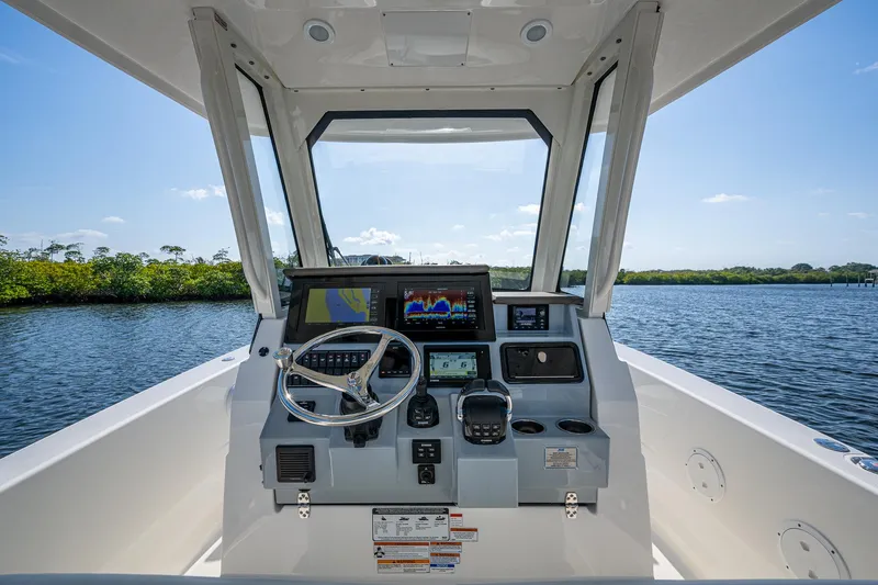 Slide: The Image of 2021 Pursuit S 288 Sport boat helm with modern controls and scenic water view. - 29