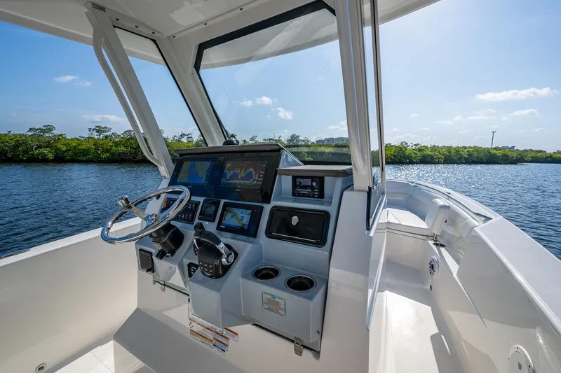 Slide: The Image of 2021 Pursuit S 288 Sport boat cockpit with modern controls and scenic water view. - 30