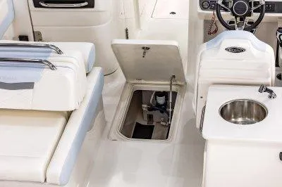 Slide: The Image of 2025 Robalo R257 DC boat interior with open hatch and sink. - 16