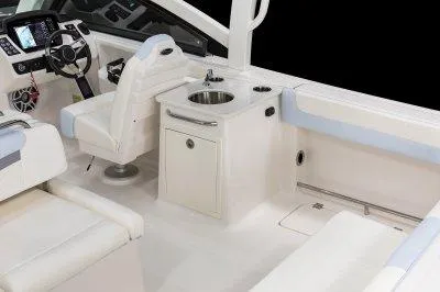 Slide: The Image of 2025 Robalo R257 DC boat interior with steering wheel, sink, and seating area. - 22