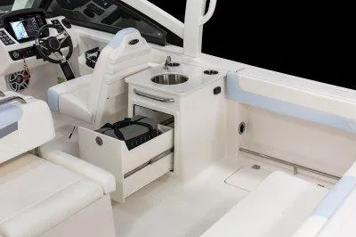 Slide: The Image of 2025 Robalo R257 DC boat interior with steering wheel, sink, and seating area. - 23