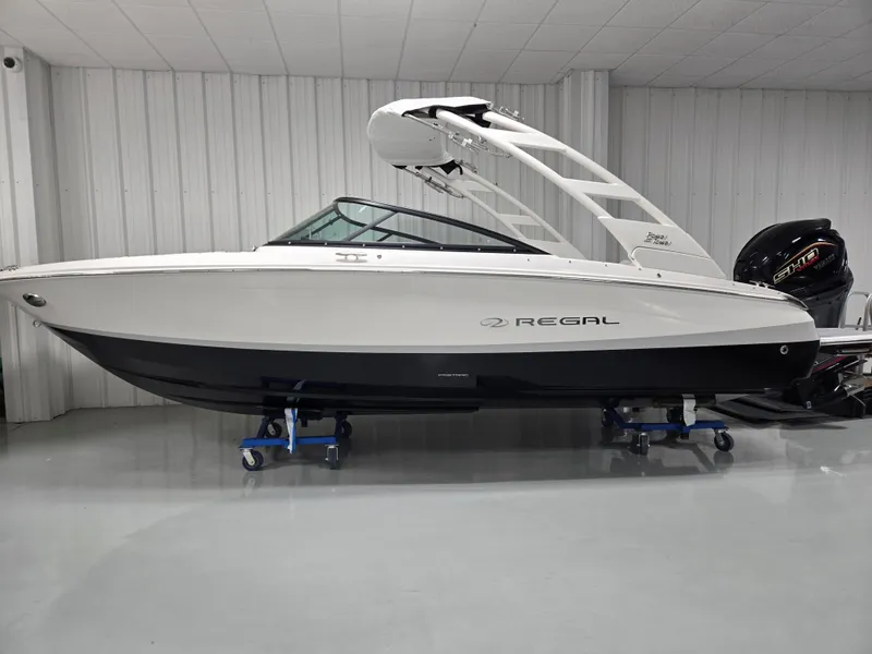 Slide: The Image of 2026 Regal LX2 boat in showroom, sleek design, white and black hull, modern features. - 0