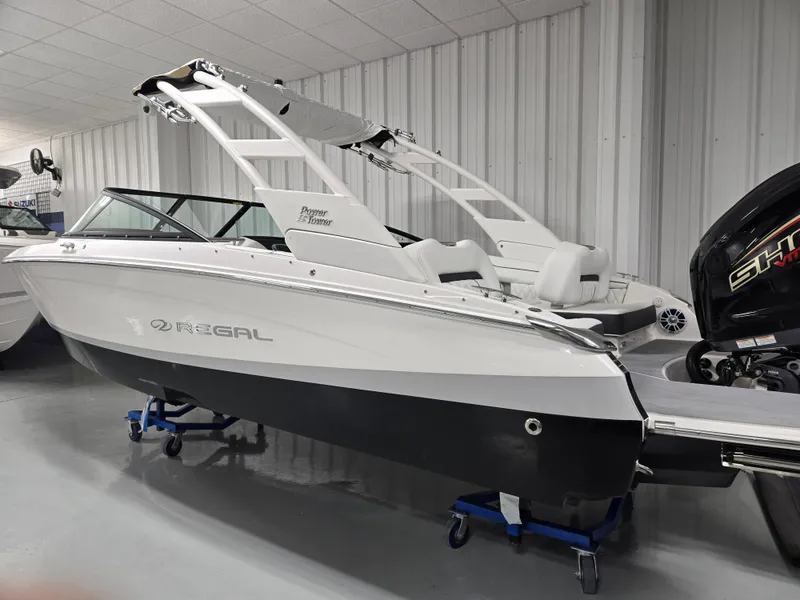 Slide: The Image of 2026 Regal LX2 boat in showroom, sleek design, white and black exterior. - 10