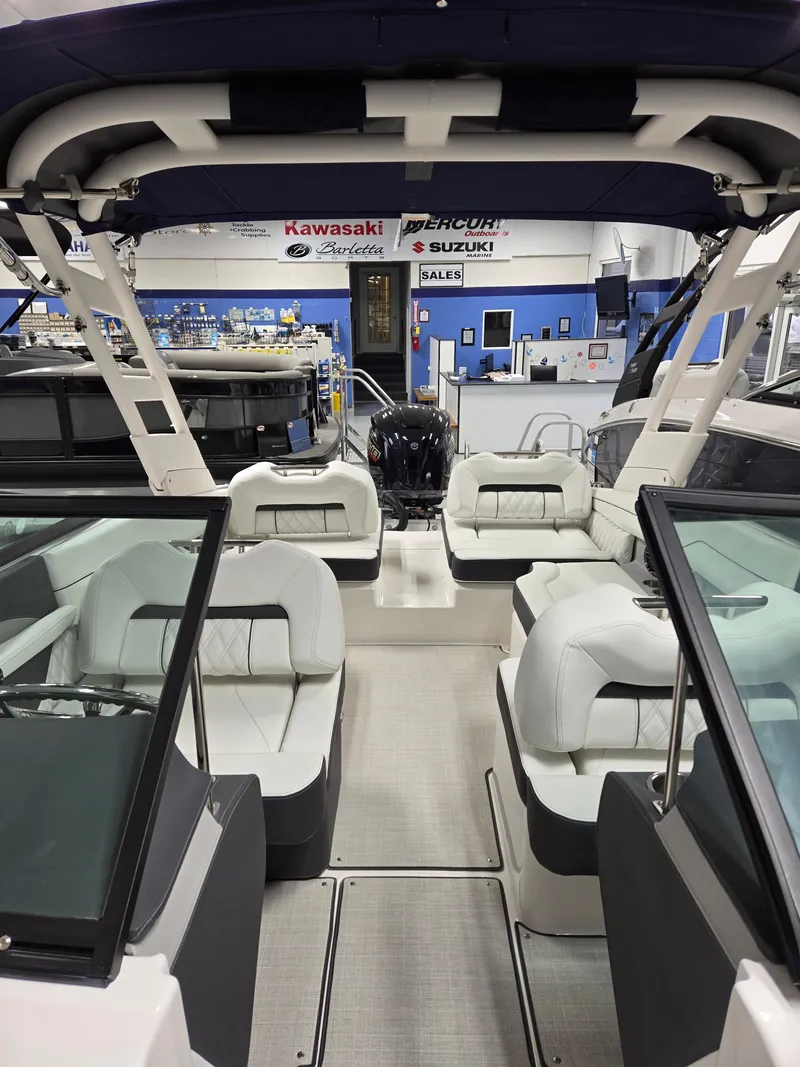 Slide: The Image of 2026 Regal LX2 boat interior with white seating and modern design in showroom. - 4