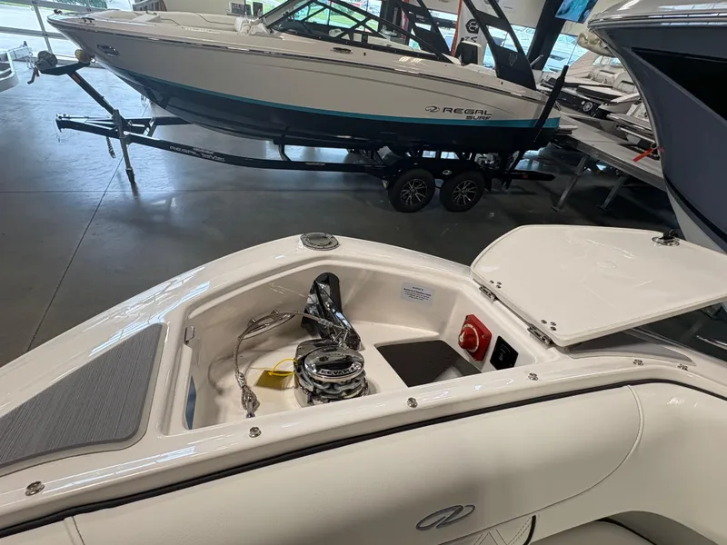 Slide: The Image of 2026 Regal LS6 Surf boat interior with open storage compartment in showroom. - 6
