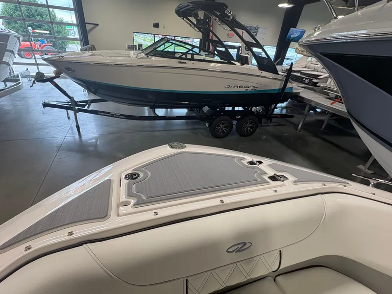Slide: The Image of 2026 Regal LS6 Surf boat displayed in a showroom, showcasing sleek design and modern features. - 7