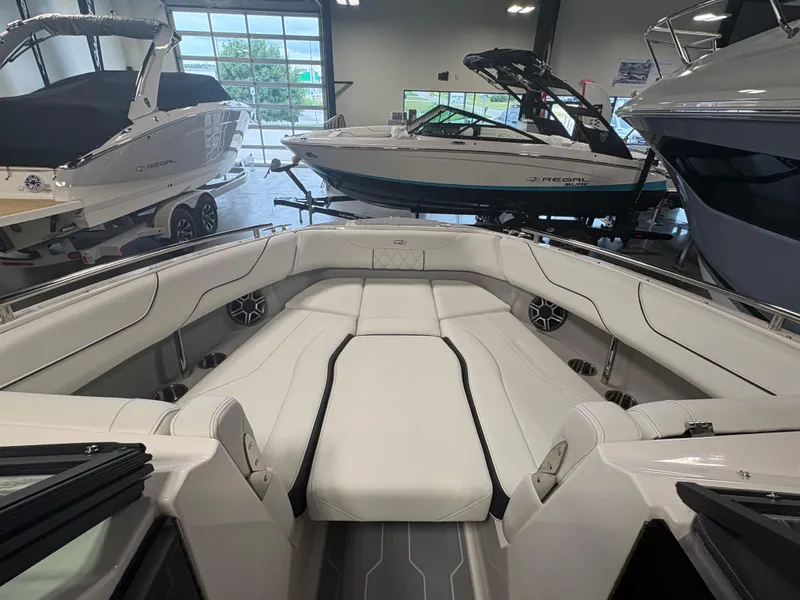Slide: The Image of 2026 Regal LS6 Surf boat interior with luxurious white seating in showroom. - 8