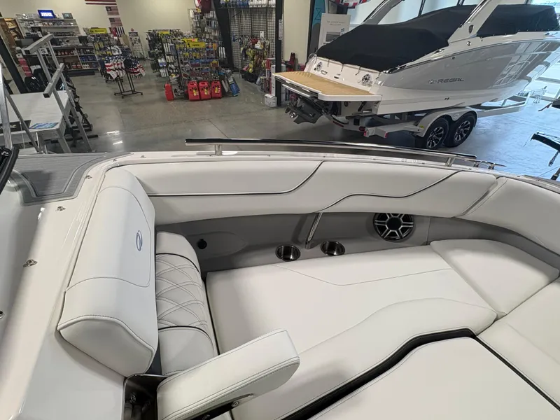 Slide: The Image of 2026 Regal LS6 Surf boat interior with white seating in showroom. - 9