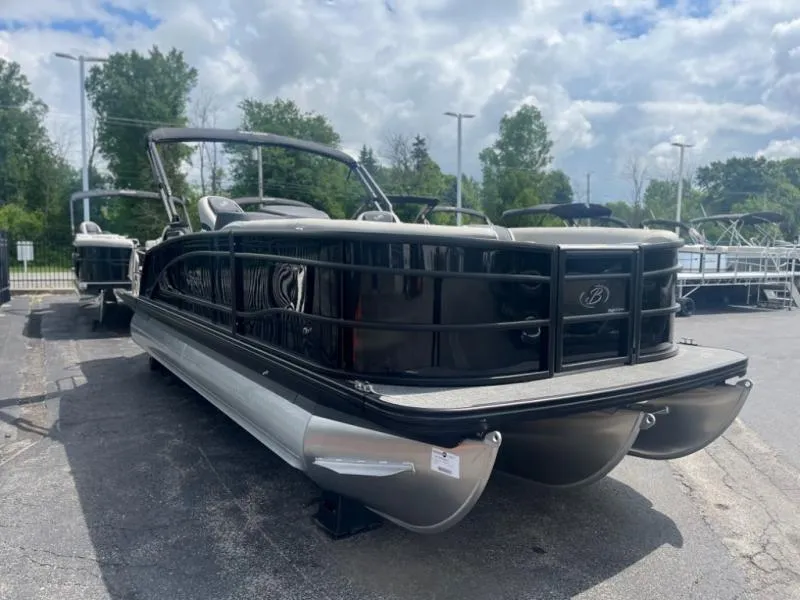 Slide: The Image of 2024 Lusso Ultra-Lounge L23UC pontoon boat in a parking lot, under a cloudy sky. - 1