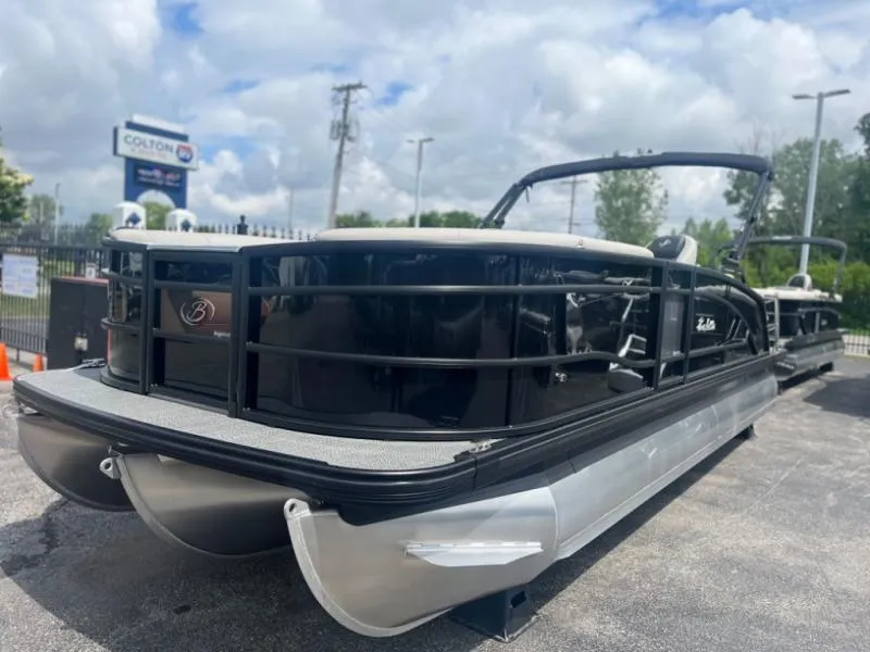 Slide: The Image of 2024 Lusso Ultra-Lounge L23UC pontoon boat with sleek black design, parked outdoors. - 3