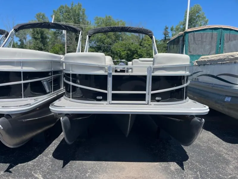 Slide: The Image of 2024 Vista 20 LR pontoon boat, sleek design, parked outdoors, surrounded by trees. - 3