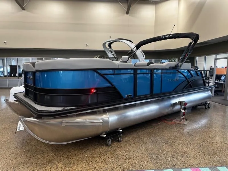 Slide: The Image of 2025 L3 DLZ Bar pontoon boat with blue and silver design in showroom. - 3