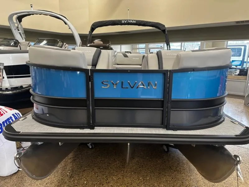 Slide: The Image of 2025 Sylvan pontoon boat, blue and gray design, displayed indoors. - 5