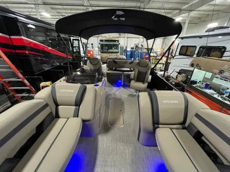 Slide: The Image of Interior of 2025 L3 DLZ DH Bar pontoon boat with beige seating and blue lighting. - 5