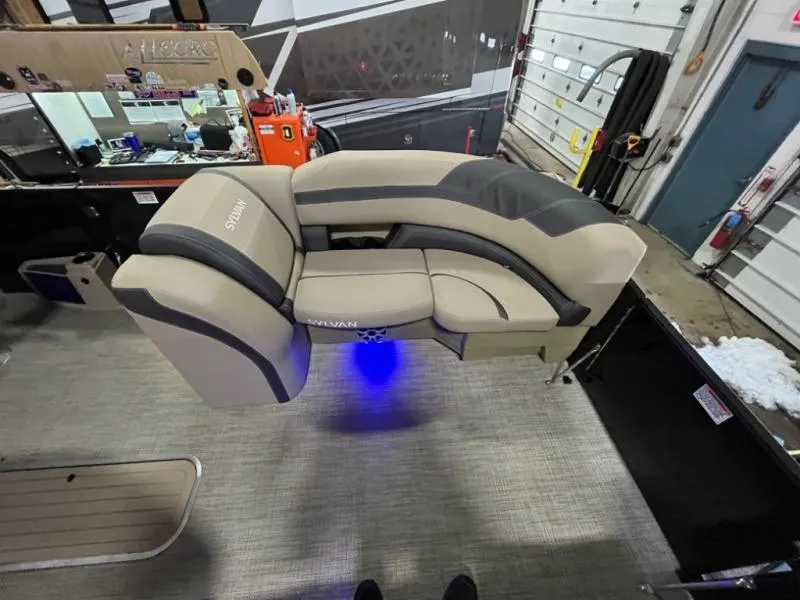 Slide: The Image of Luxurious boat seating with ambient blue lighting, featuring Sylvan branding, in a workshop setting. - 7