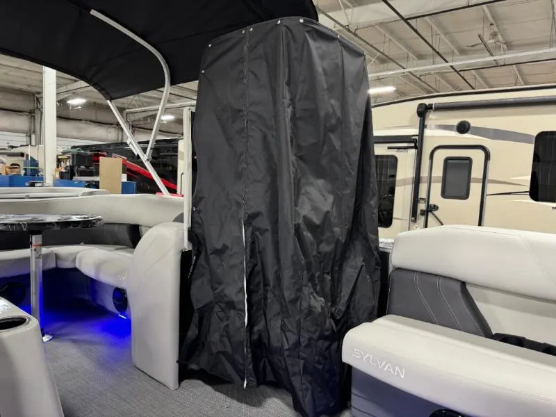 Slide: The Image of 2025 Mirage Cruise 8520 CRS interior with black privacy curtain and gray seating. - 23