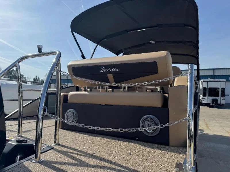 Slide: The Image of 2025 Cabrio Ultra-Entertainer C24UE boat with beige seating and canopy, docked outdoors. - 10