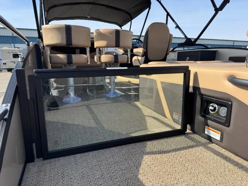 Slide: The Image of 2025 Cabrio Ultra-Entertainer C24UE boat interior with beige seating and glass partition. - 13