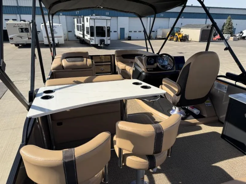 Slide: The Image of 2025 Cabrio Ultra-Entertainer C24UE boat interior with seating and table, parked in a lot. - 15