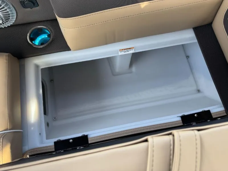 Slide: The Image of Open storage compartment in 2025 Cabrio Ultra-Entertainer C24UE boat, featuring beige seating. - 31