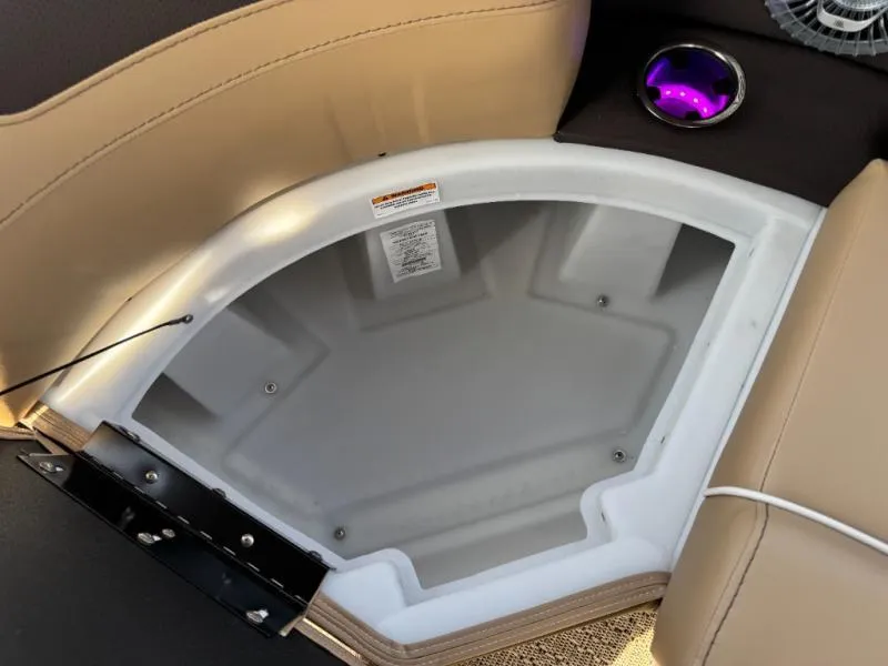 Slide: The Image of 2025 Cabrio Ultra-Entertainer C24UE storage compartment with cup holder and beige seating. - 32