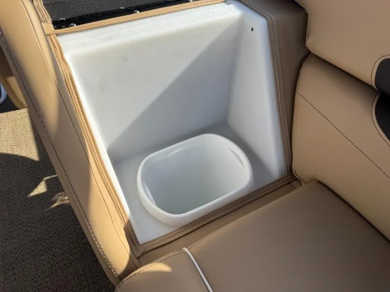 Slide: The Image of Built-in cooler compartment in 2025 Cabrio Ultra-Entertainer C24UE boat with beige seating. - 33