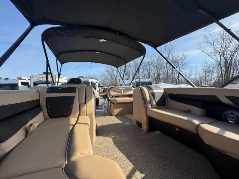 Slide: The Image of 2025 Cabrio Ultra-Entertainer C24UE boat interior with beige seating and canopy. - 7