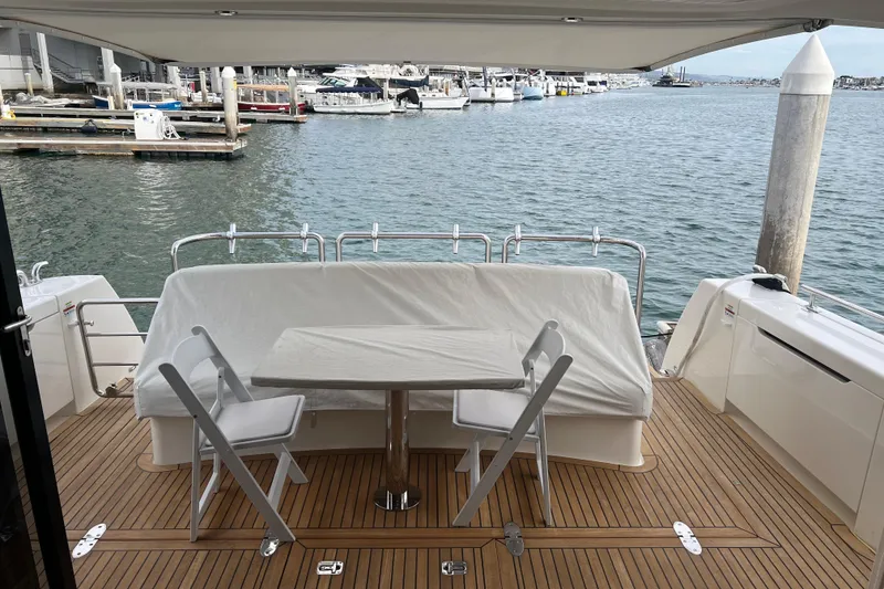 Slide: The Image of 2020 Maritimo M51 yacht deck with table and chairs, docked at marina. - 76