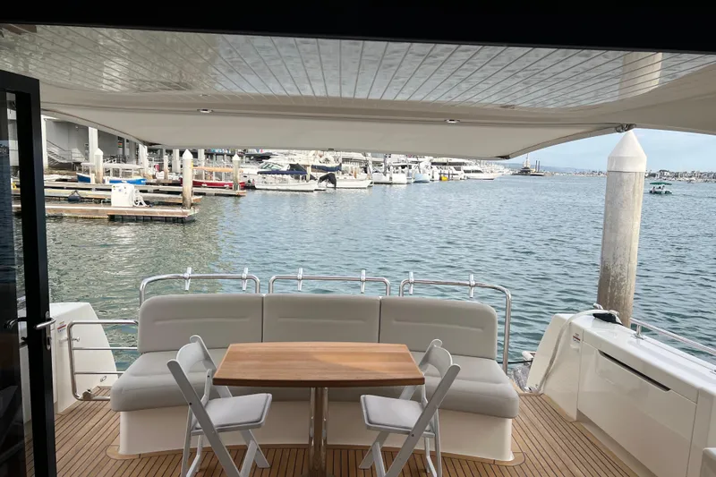 Slide: The Image of 2020 Maritimo M51 yacht deck with seating and table, overlooking marina. - 82