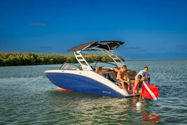 Slide: The Image of 2025 Yamaha Boats 252SD on water, family enjoying sunny day, blue sky backdrop. - 9