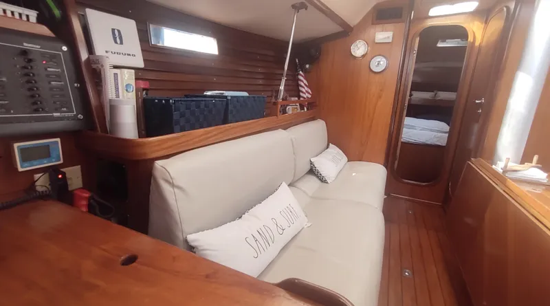 Slide: The Image of Interior of 1990 Beneteau Oceanis 390 sailboat with cozy seating and wooden finish. - 10