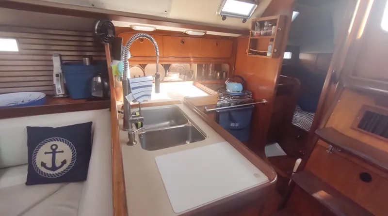 Slide: The Image of Interior of 1990 Beneteau Oceanis 390 sailboat, featuring kitchen and seating area. - 14