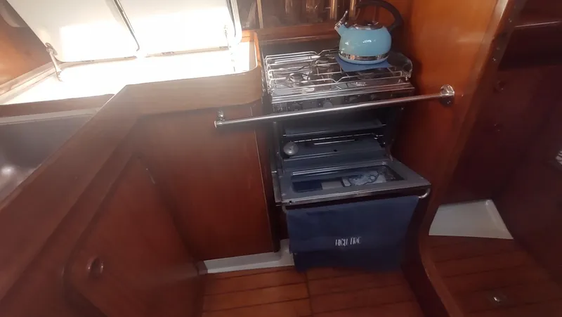 Slide: The Image of Interior of 1990 Beneteau Oceanis 390 yacht kitchen with stove and wooden cabinetry. - 16