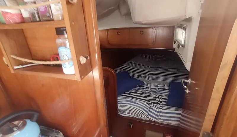 Slide: The Image of Cozy cabin interior of 1990 Beneteau Oceanis 390 sailboat with striped bedding and wooden furnishings. - 18