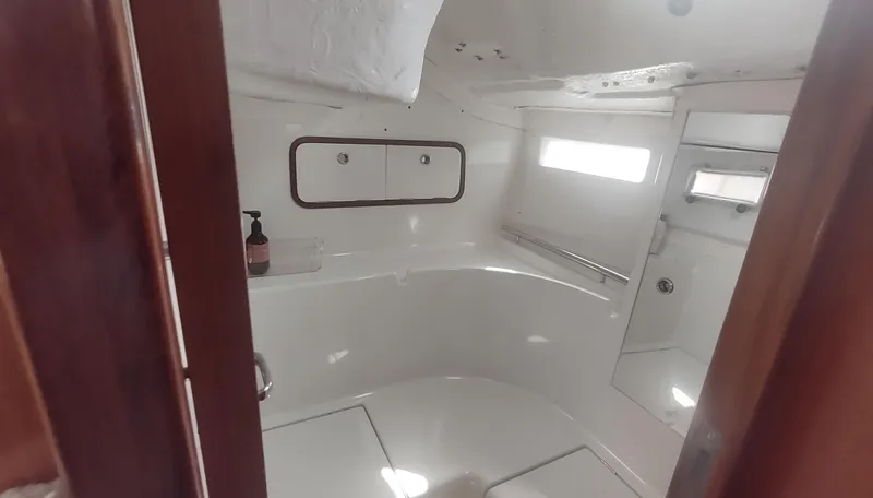 Slide: The Image of Interior of 1990 Beneteau Oceanis 390 yacht bathroom with white fixtures and wooden accents. - 23