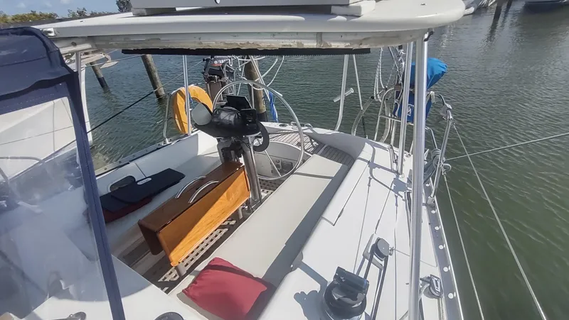 Slide: The Image of 1990 Beneteau Oceanis 390 sailboat cockpit with steering wheel and seating, docked in marina. - 3